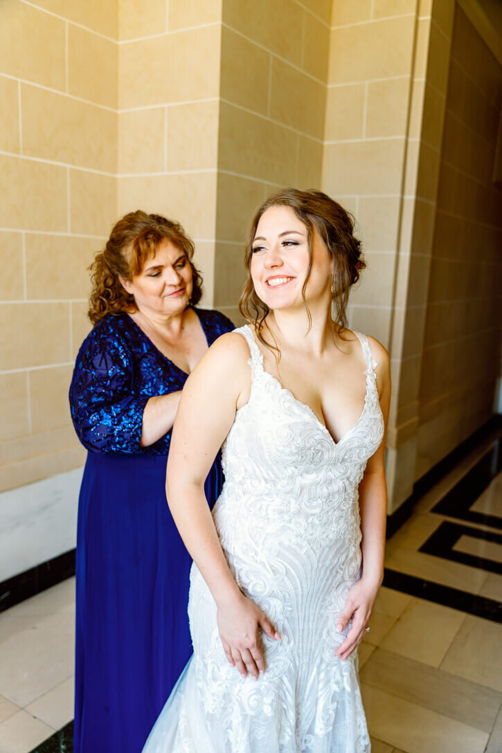 Mother of the bride zipping up her daughters dress on her wedding at the Dayton Masonic Temple.