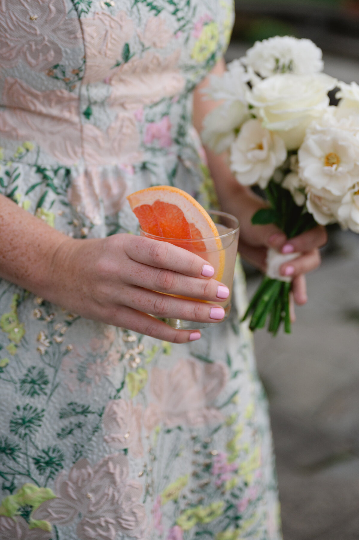 Woman holding a cocktail and a bouquet at a wedding at the Chicago Botanic Gardens