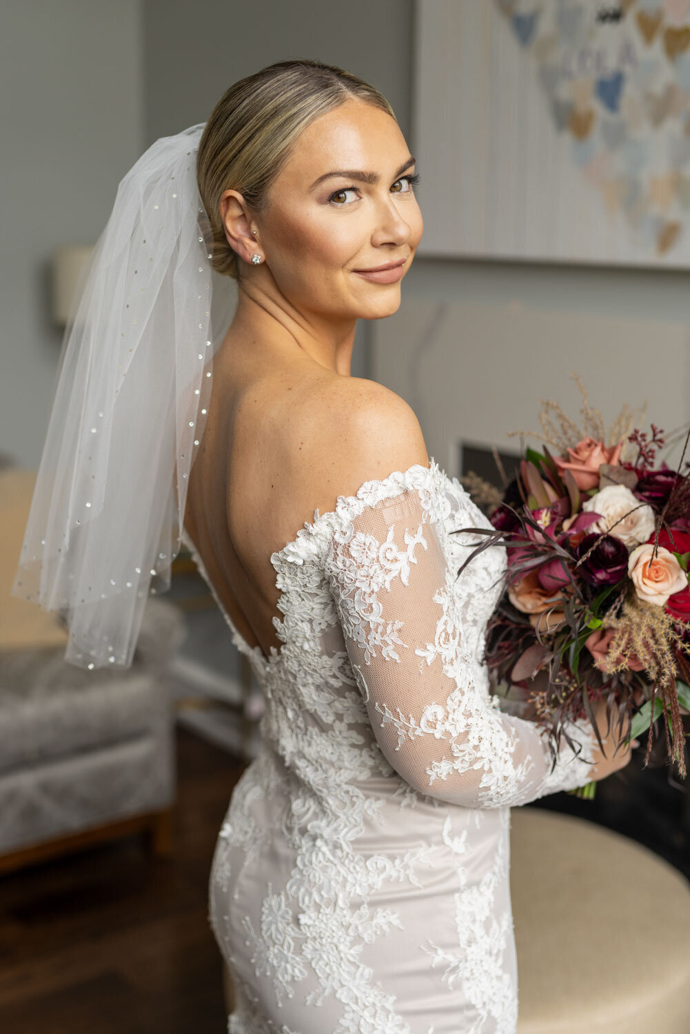 A woman in a wedding dress and veil is holding a bouquet of flowers.
