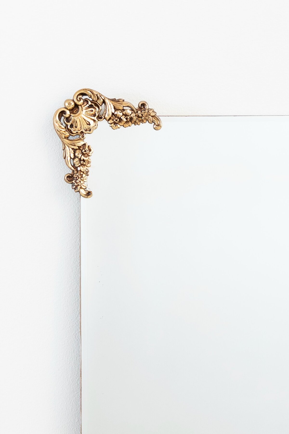 Large gold mirror with ornate ornaments on the corners 