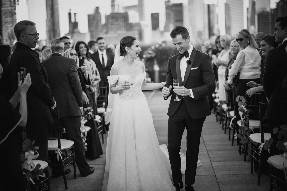 A couple exits their ceremony on the roof at a Tribeca Rooftop wedding in Manhattan