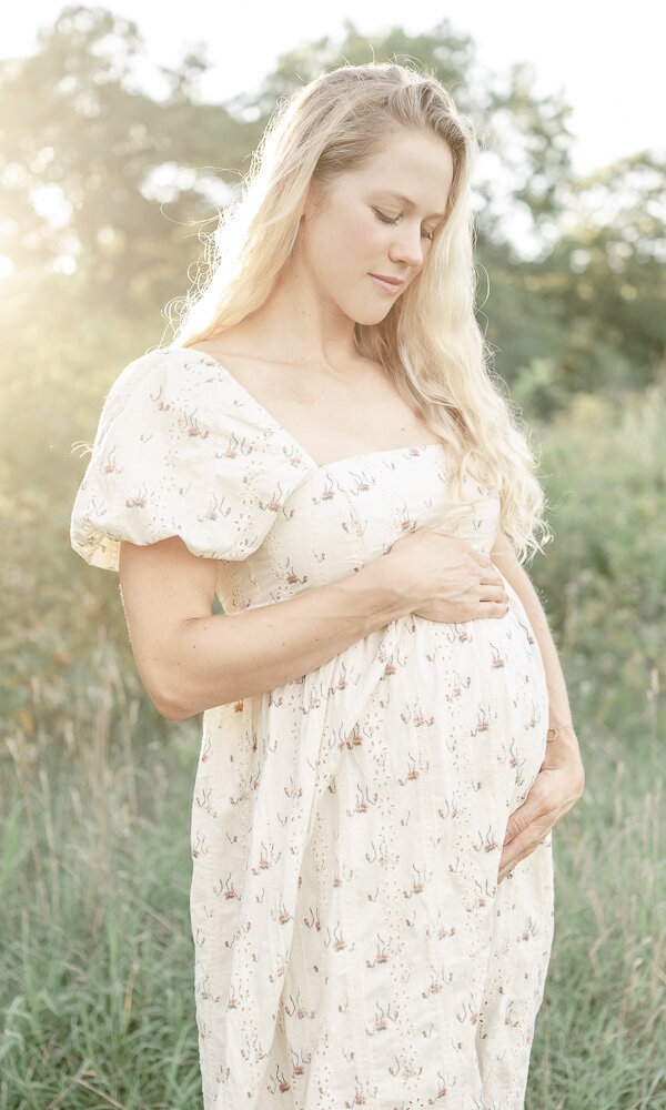 Pregnant woman stands in a field at golden hour at Smith Park By Nashville maternity photographer Kristie Lloyd