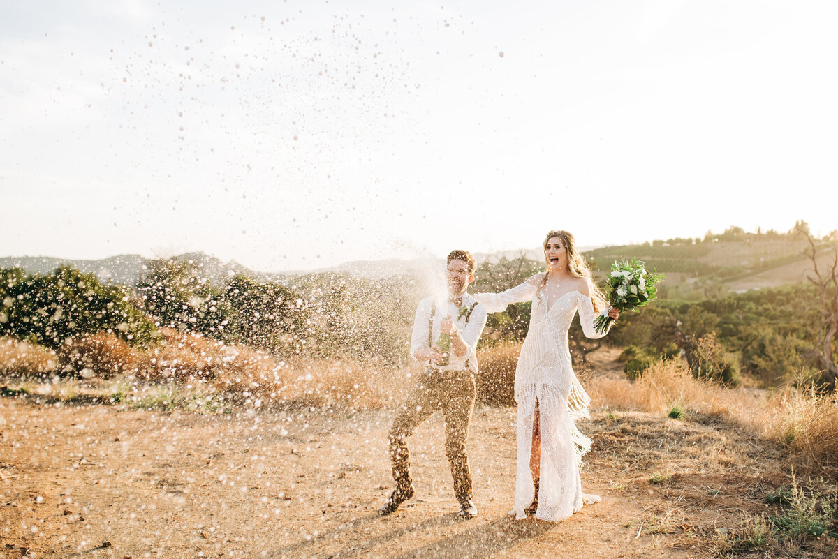 Boho Bride and Groom Pop champgane after wedding ceremony in Temecula ca