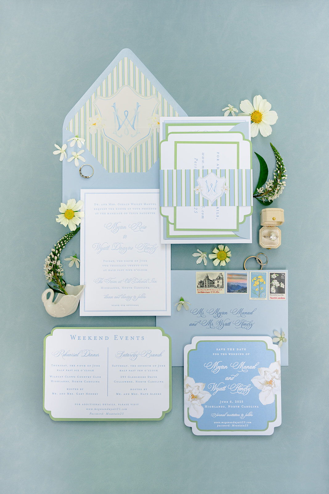 Luxury wedding invitation suite in soft blue and green tones with floral accents, displayed flatlay-style at Old Edwards Inn in Highlands, North Carolina.
