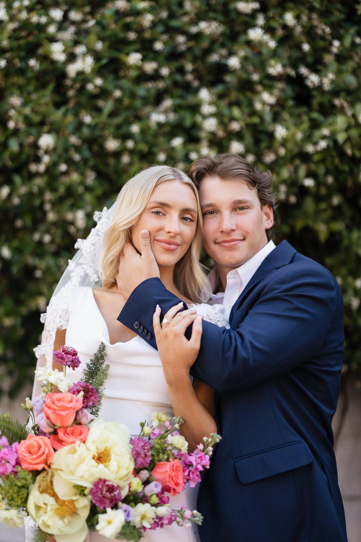 Couple looking at the camera and smiling on their wedding day.