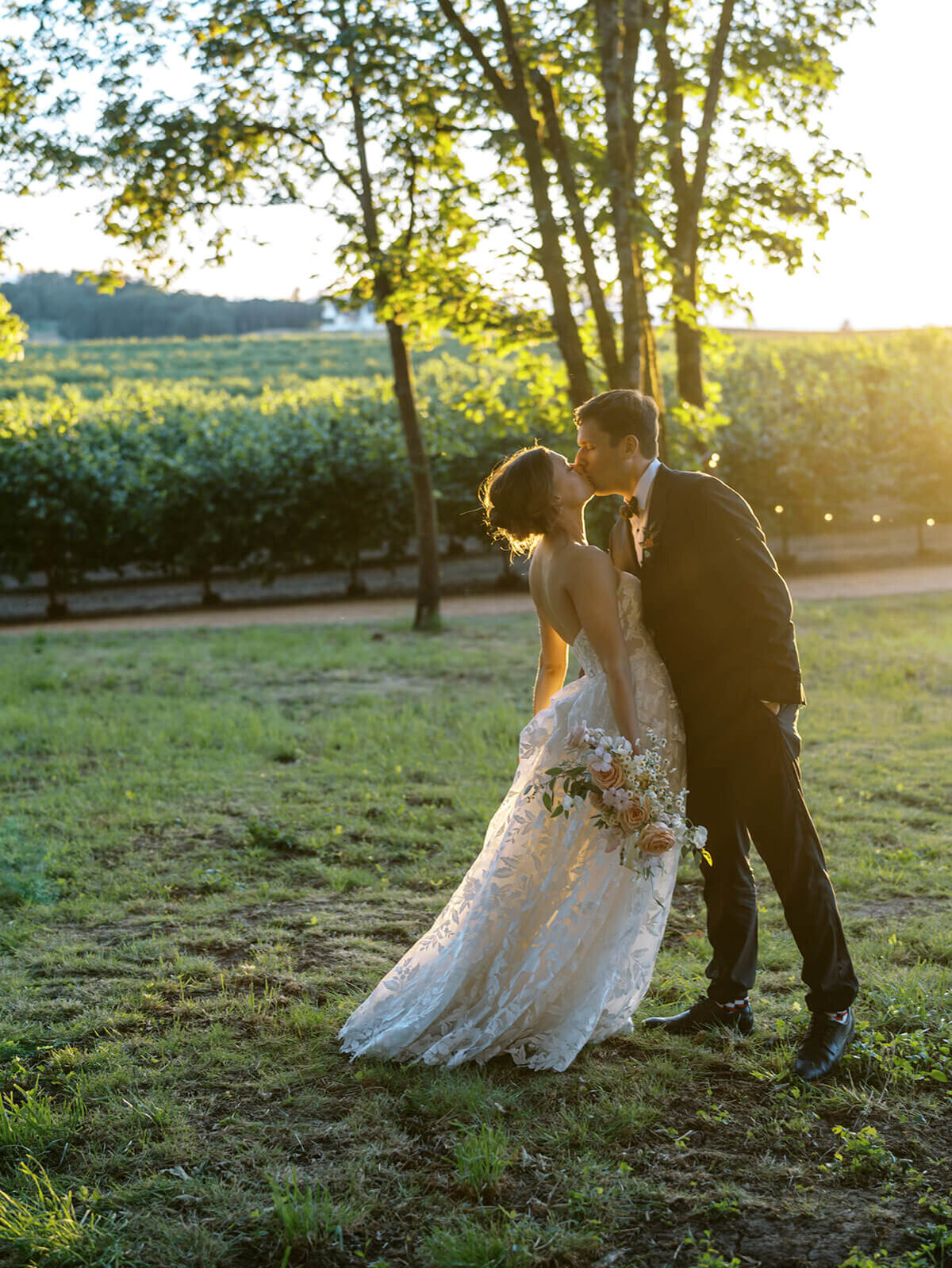 A bride leaning back while kissing a groom.