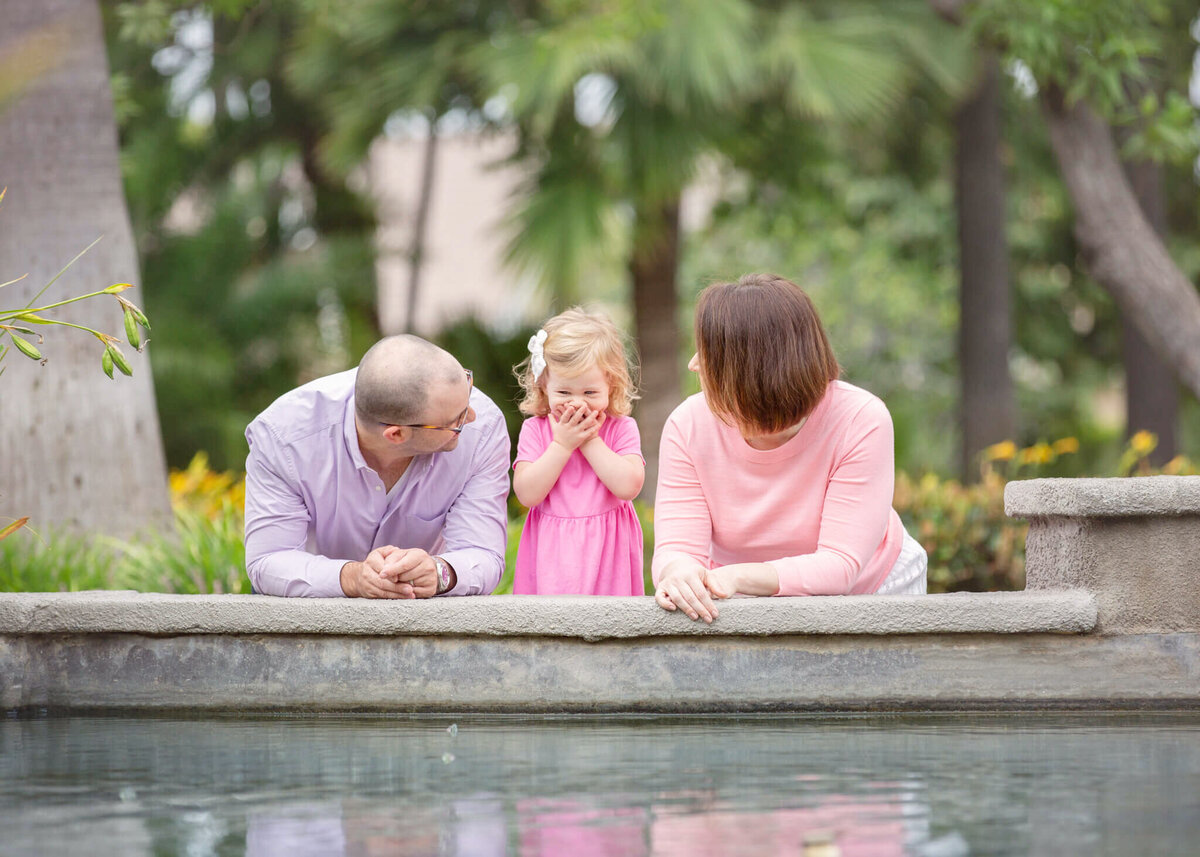 Mom and dad with their daughter at a Beverly Hills pond laughing