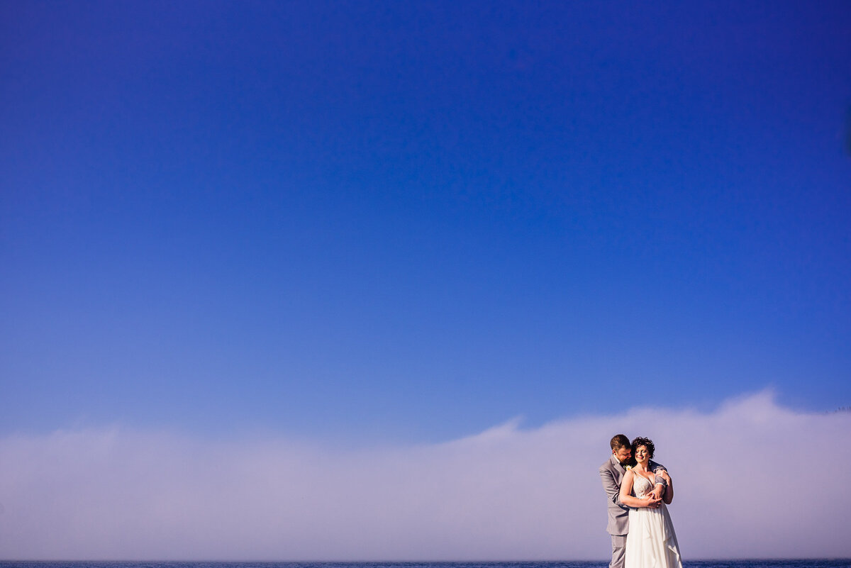 Couple in front of fog bank and ocean
