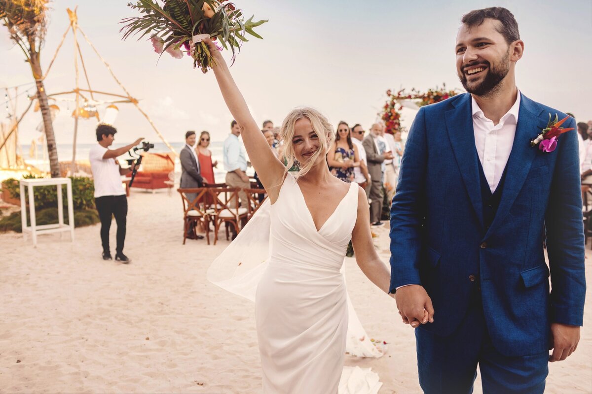 Bride celebrates with groom after wedding ceremony at Blue Venado Seaside Riviera Maya