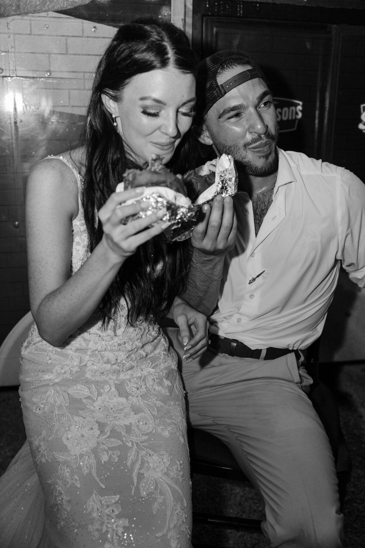 couple eating hamburgers at their reception