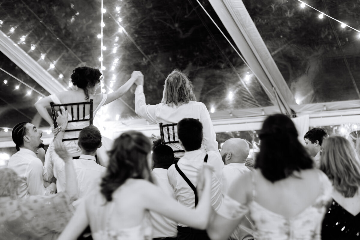 Wedding reception horah moment of bride and groom holding hands at their wedding at The Hermitage Museum in Norfolk, VA