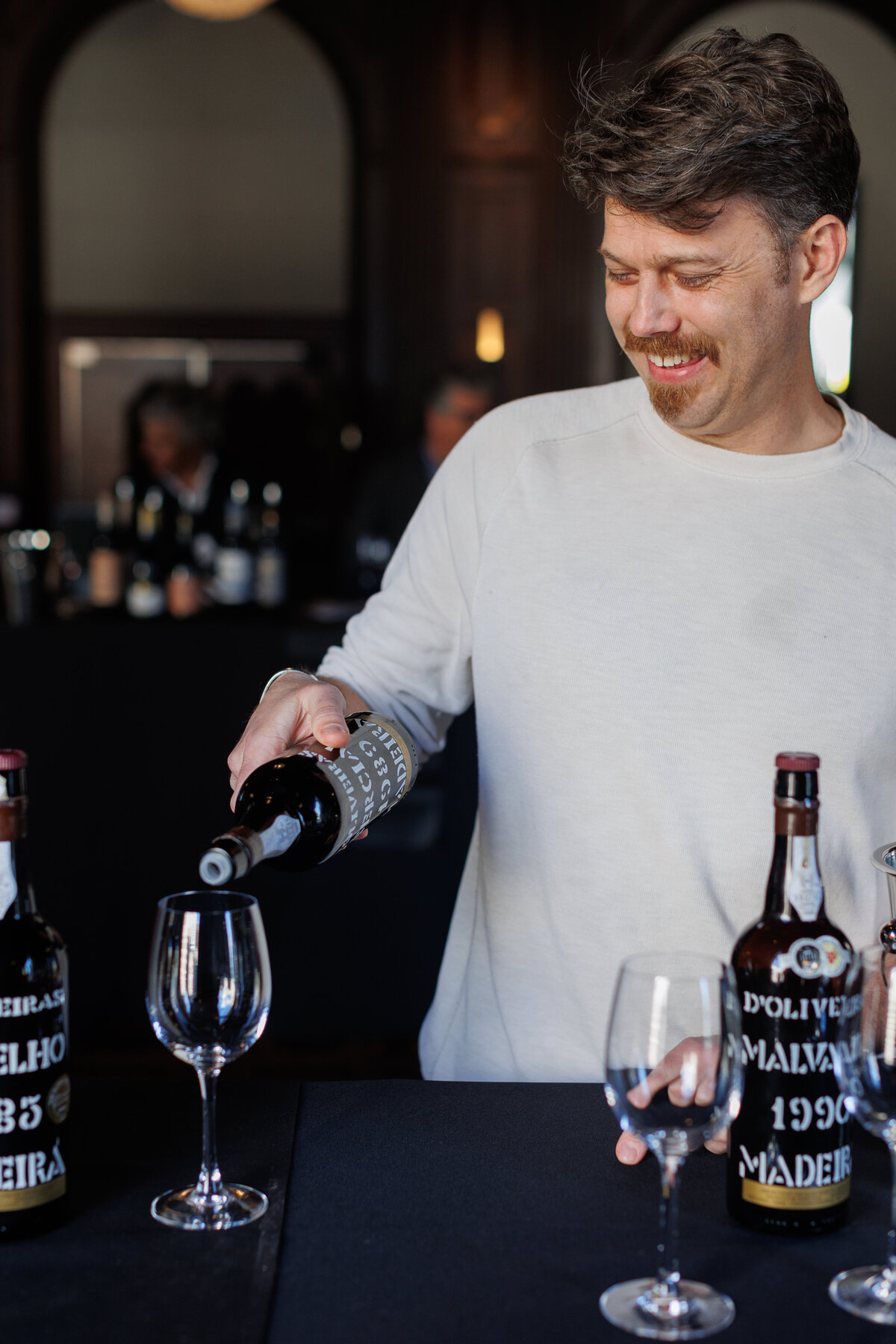 A man smiling while poring Portugal wine