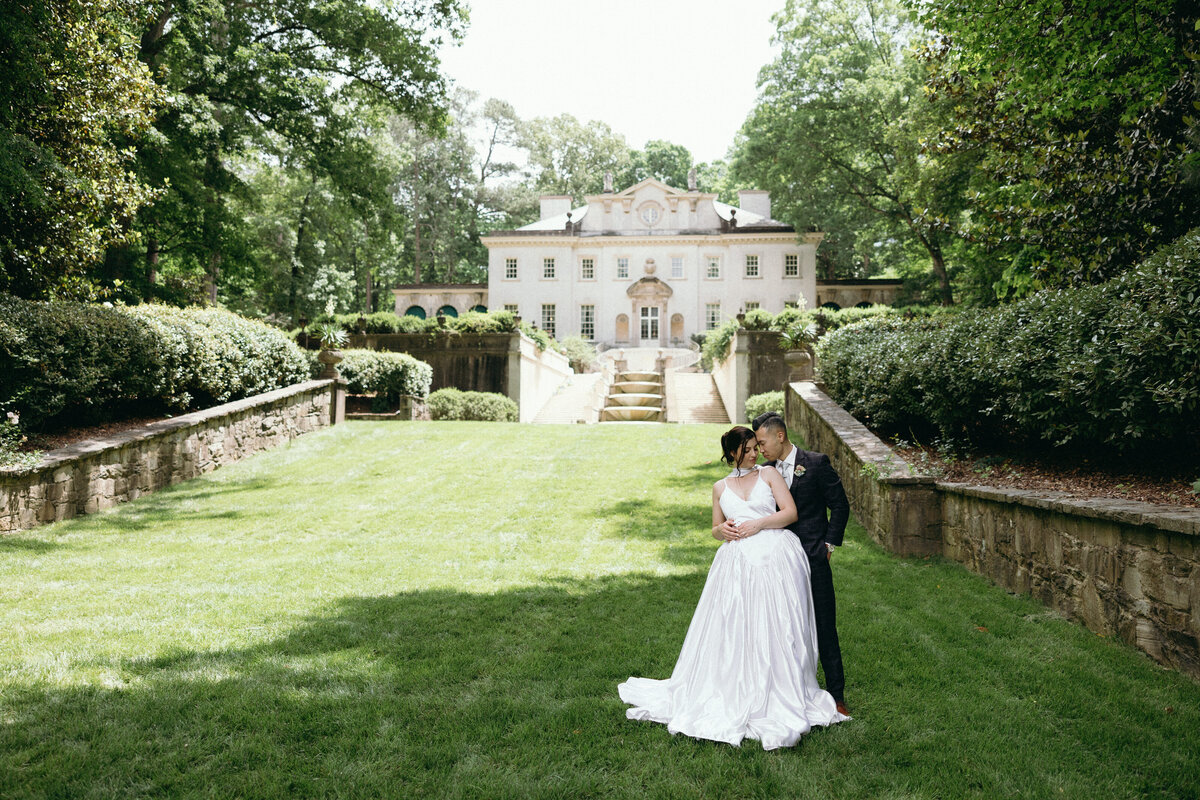 Couple standing in front of the Swan House on their wedding day.