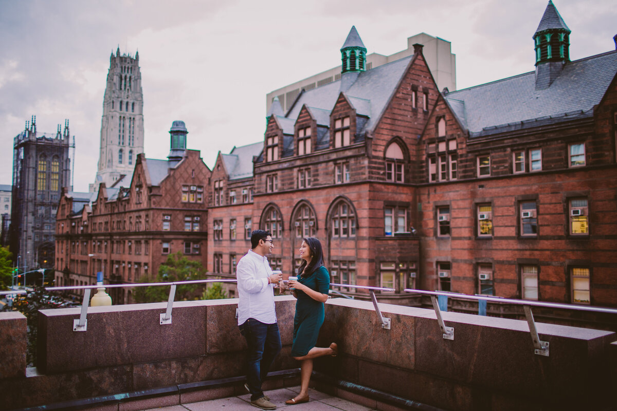 A couple having coffee together standing near the balcony at columbia university nyc