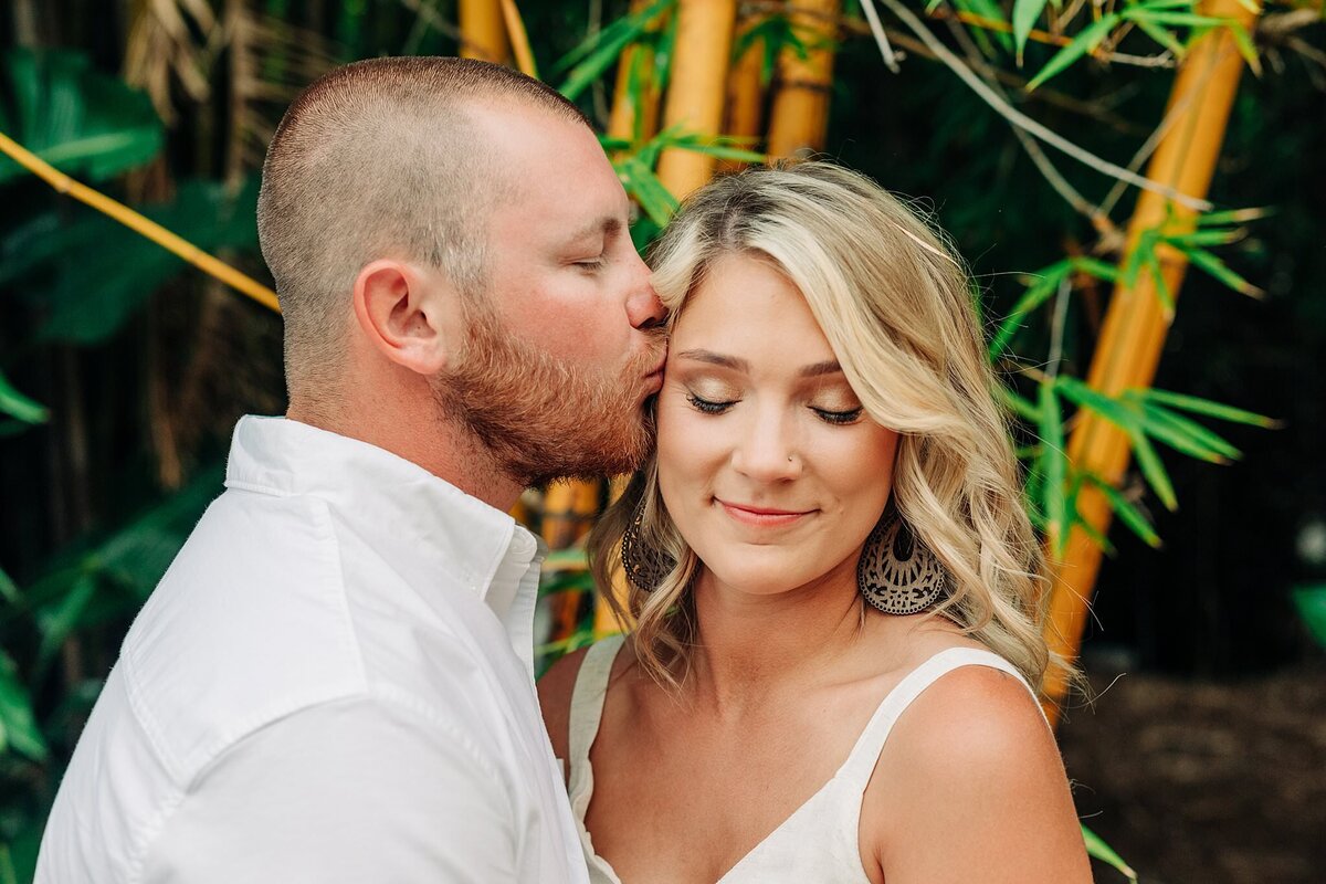 Man kissing lovingly his wife on her temple, in love