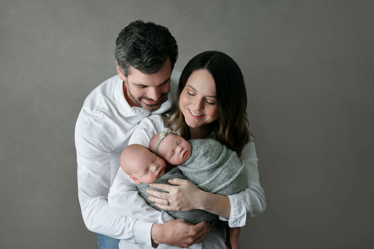 new parents holding their twin babies at at northern va photo studio