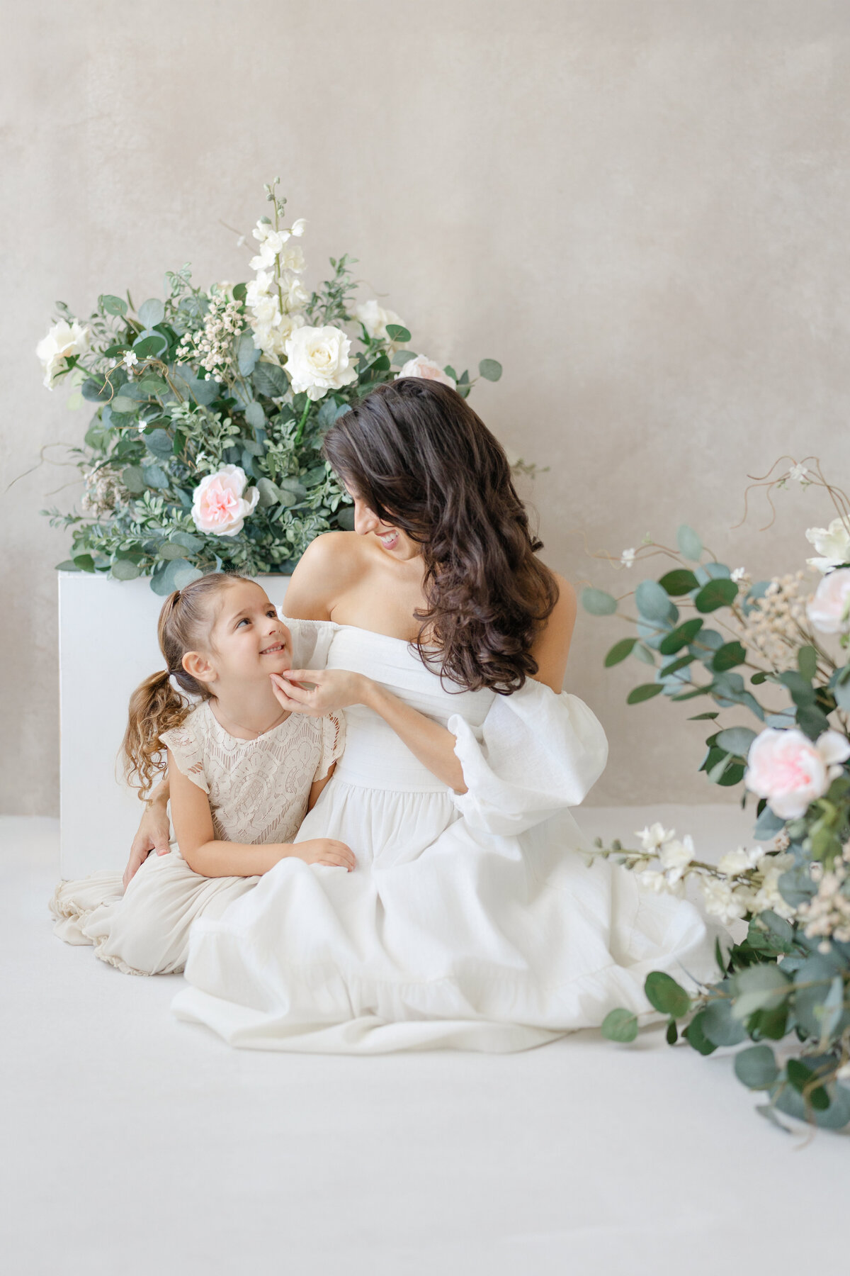 Joyful Tampa motherhood portrait of mom and daughter laughing together in soft natural light studio