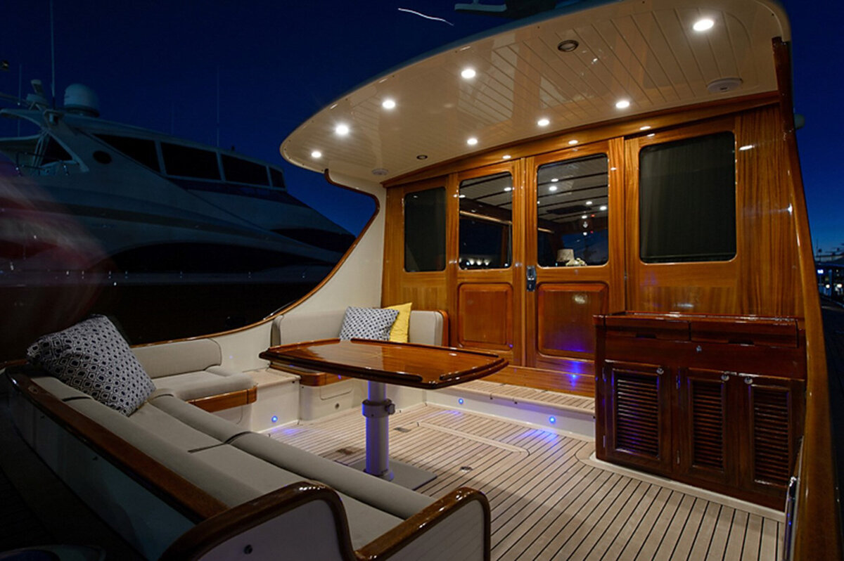 luxury yacht deck at night, illuminated by overhead lights