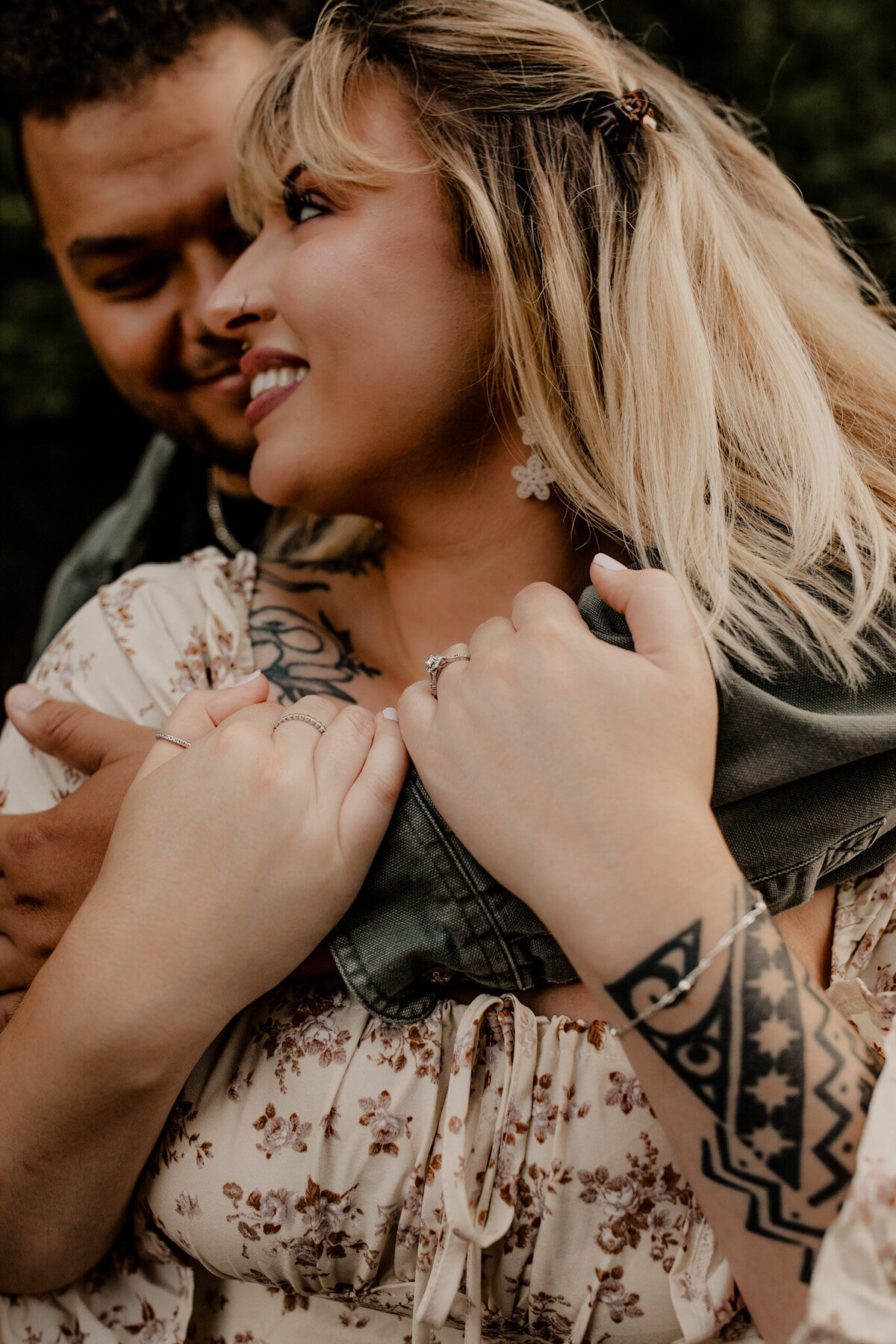 Couple holds each other in happy wooded engagement session
