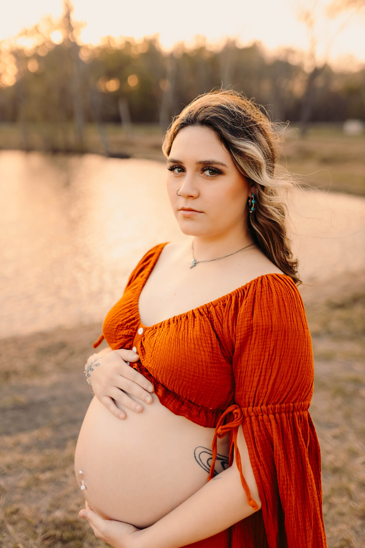 Kingwood maternity photographer – close-up maternity portrait in burnt orange gown outdoors