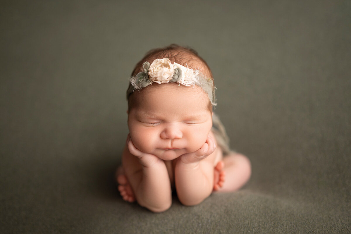 Portrait of infant resting chin on hands while asleep in our Waukesha photo studio.