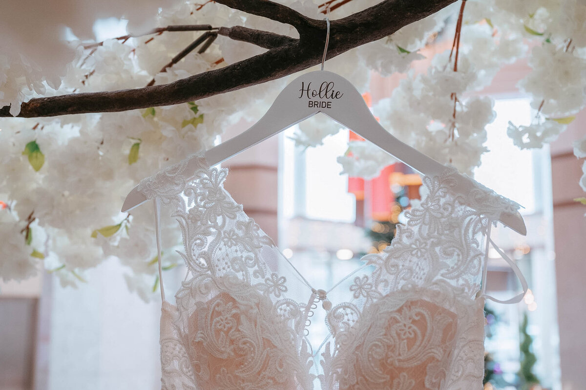 Bride’s lace dress on hanger with custom “Hello” bridal detail – wedding prep shot.
