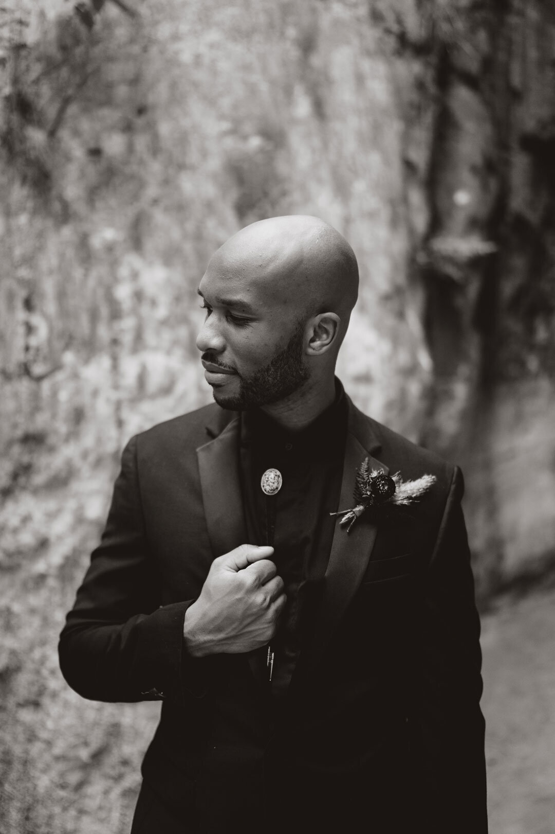Black and white photo of a Black groom wearing a black suit