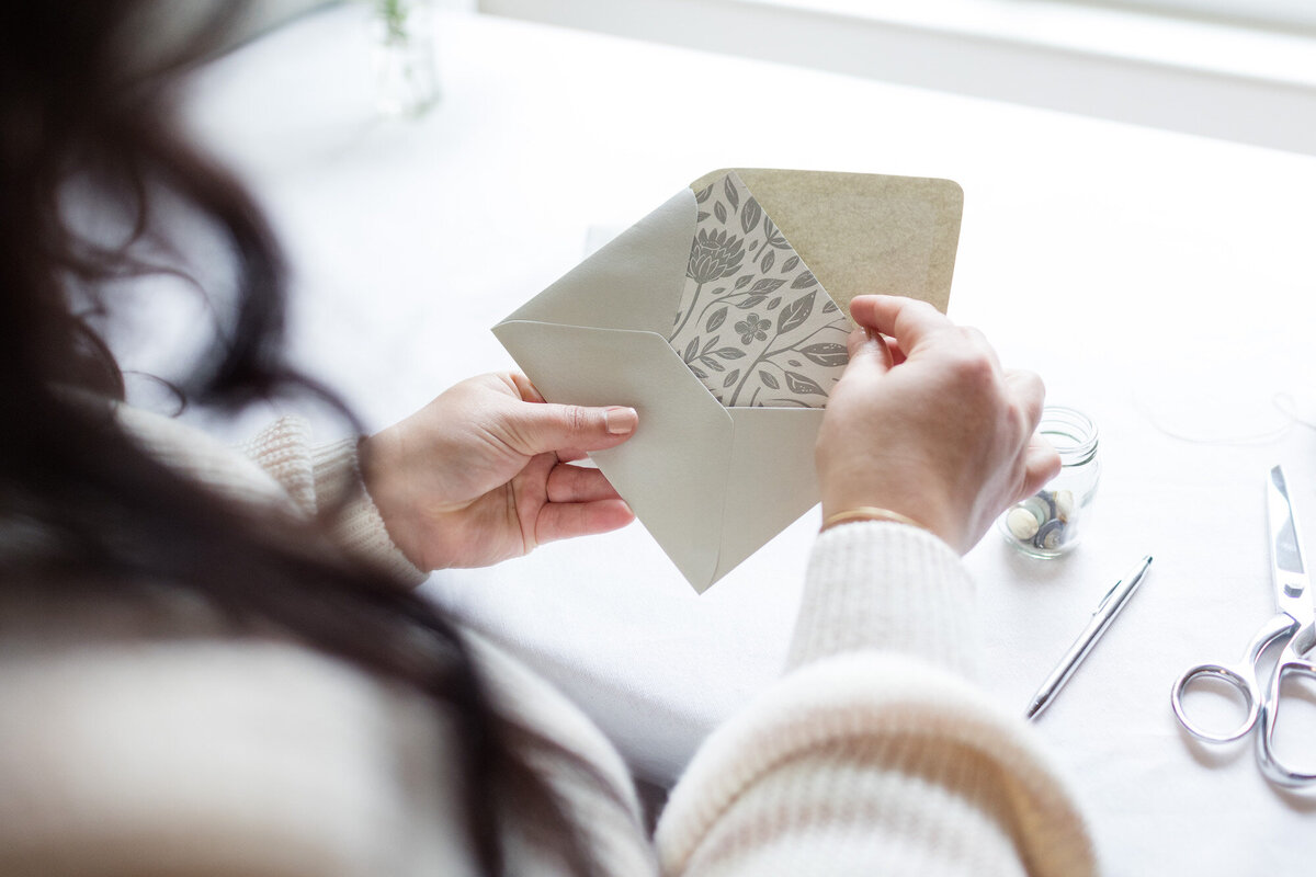 Opening a branded envelope with a floral branded note card