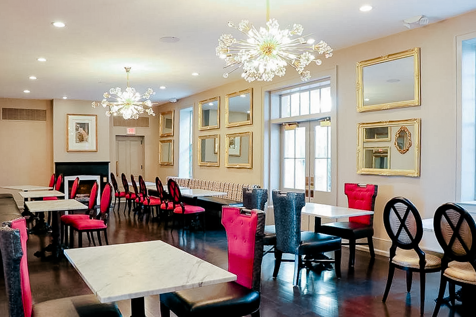 Boutique hotel dining area with red accents and ornate chandeliers
