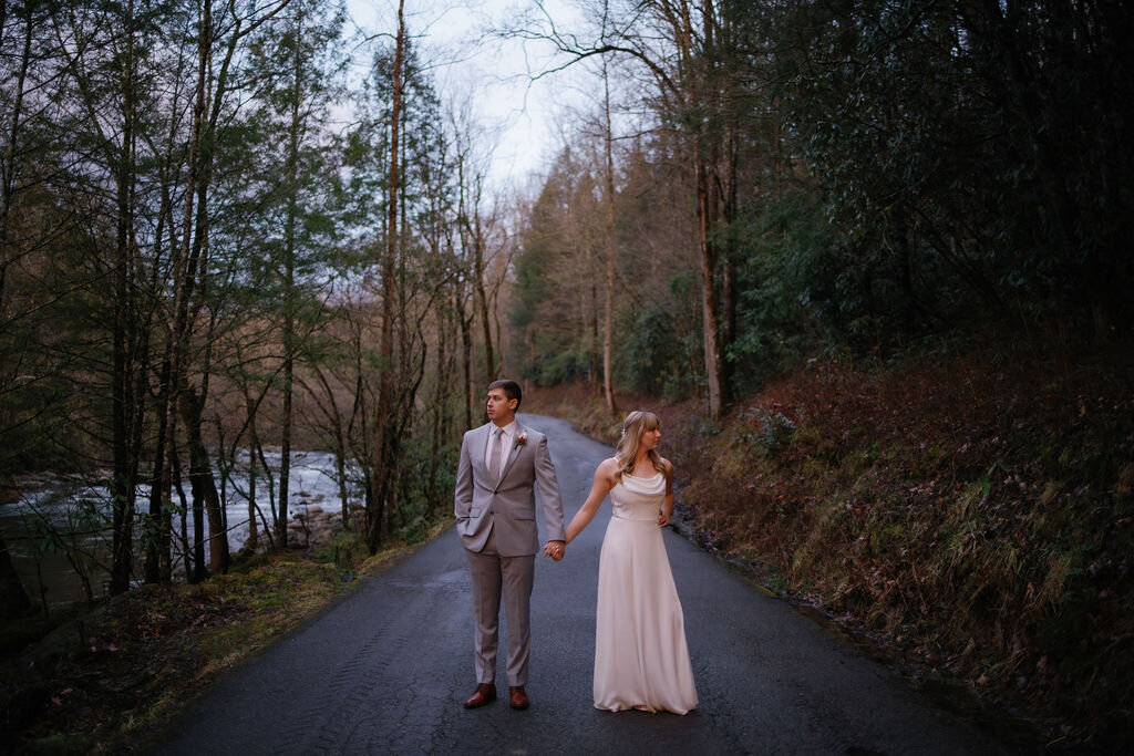 wedding couple holding hands and looking away from each other on a trail for their greenbrier wedding photos