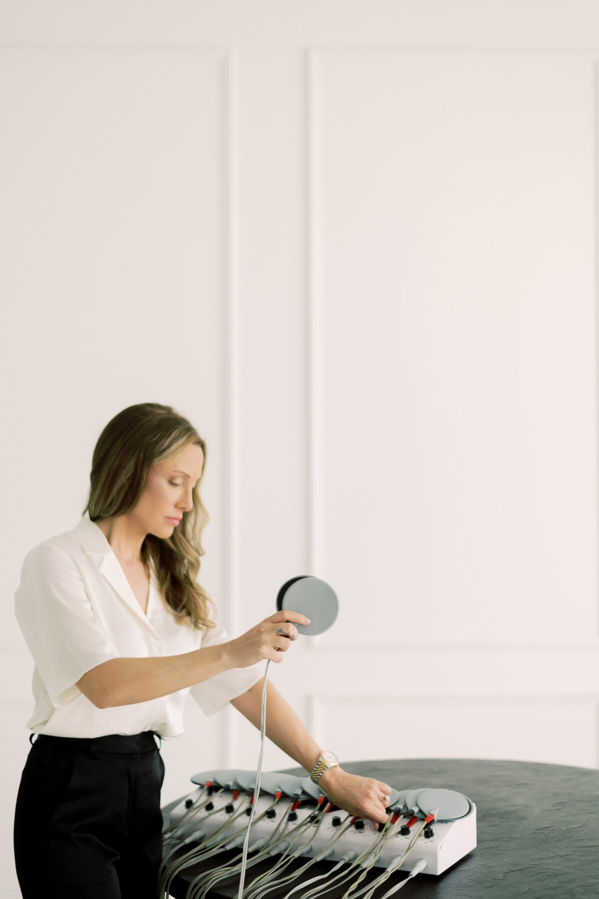 woman with body contouring device in a white room