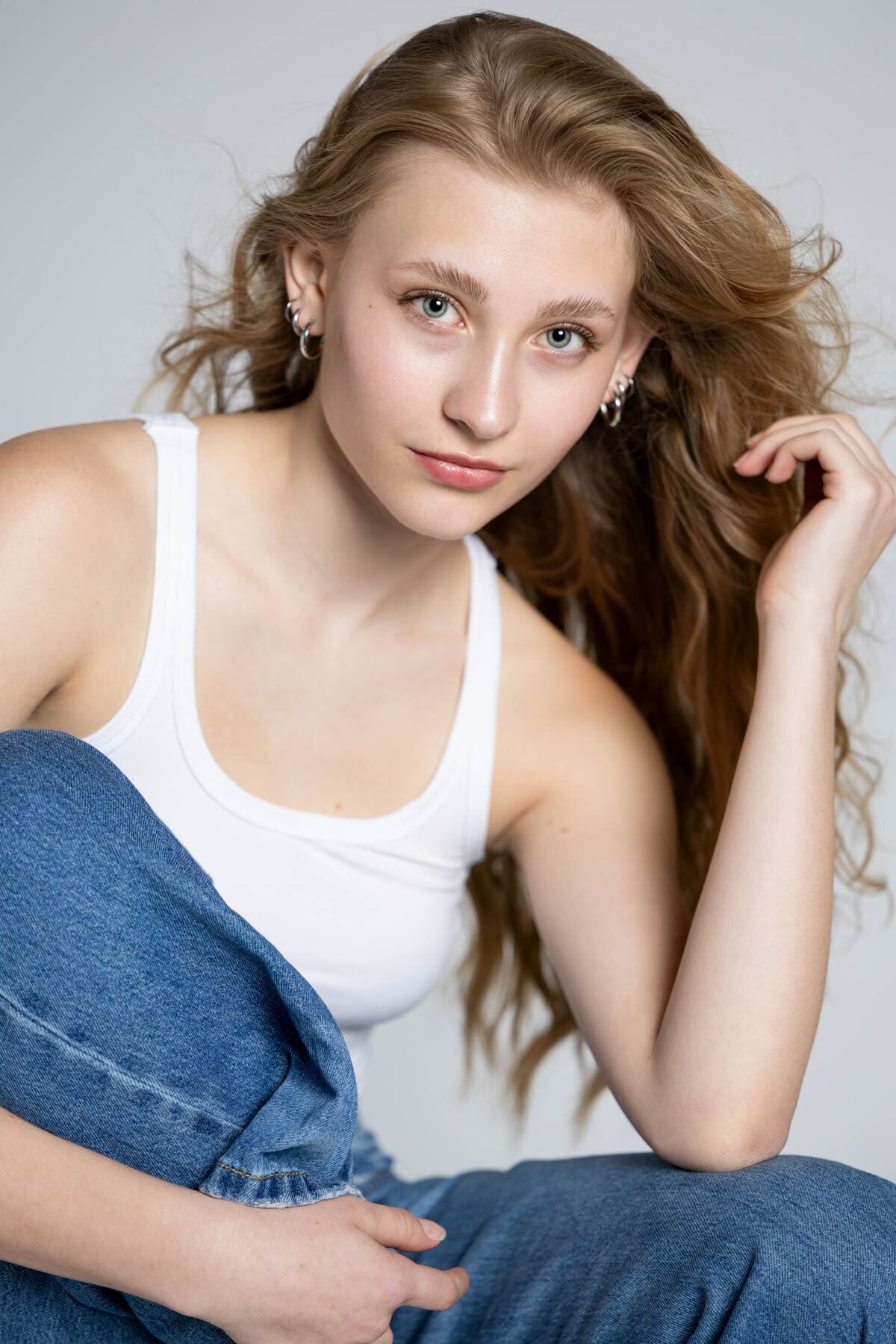 Senior pictures taken by Sara Vaz of girl posing with white tank top.