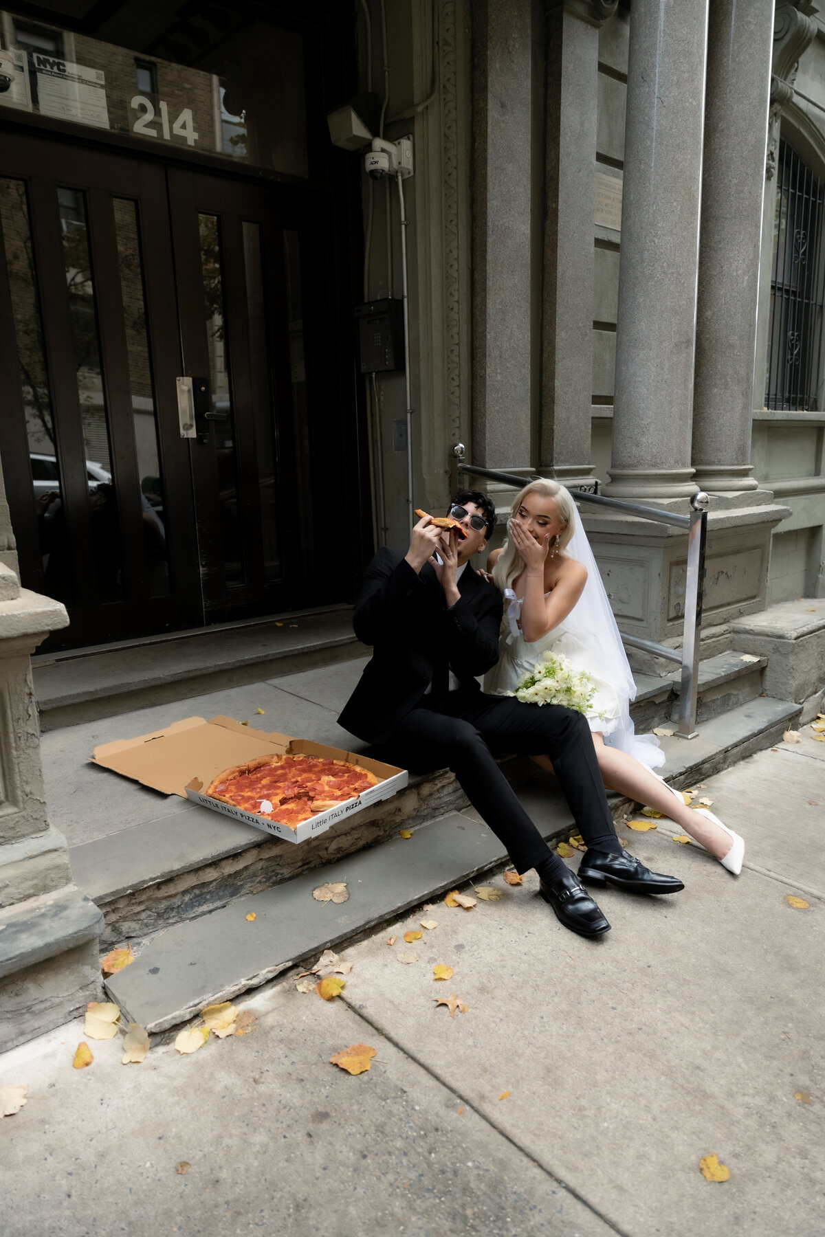 A candid photo of the couple playing with pizza slices in NYC.