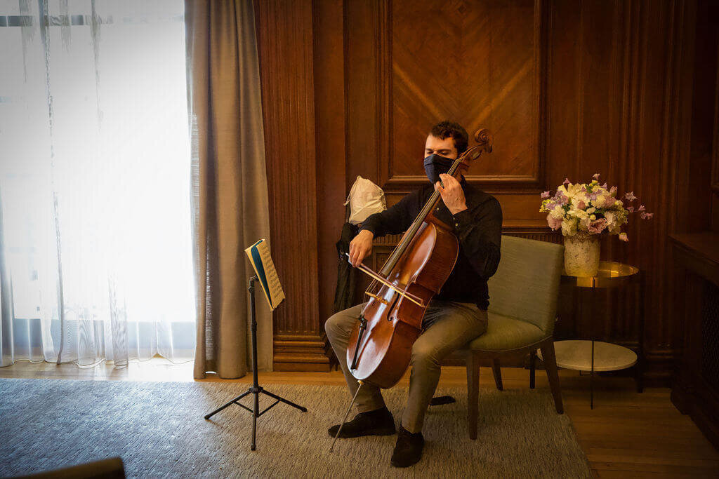 Man sat down playing Cello at gay wedding ceremony
