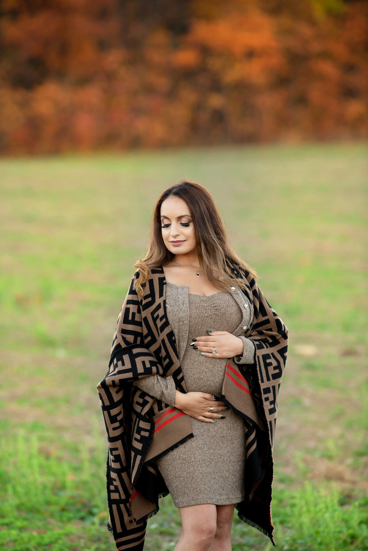 pregnant woman wearing a beige dress for her fall maternity photos in Burlington, Ontario