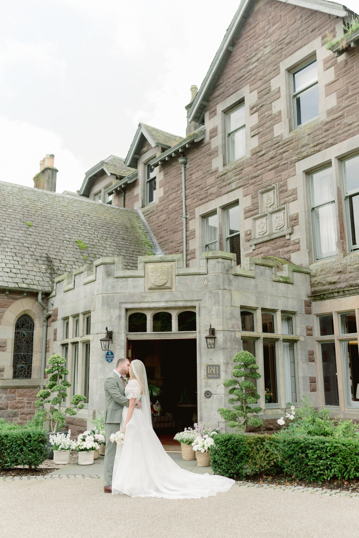 Bride and Groom by the entrace of Cromlix House, photographed by Scotland fine art wedding photographer.