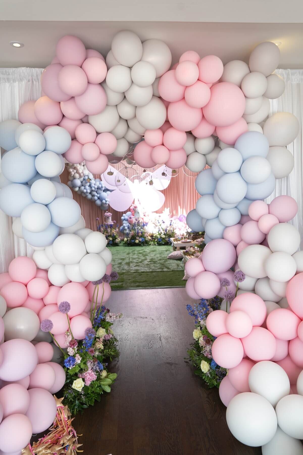 Beautiful pink, white and blue balloon arch entrance with floral runners
