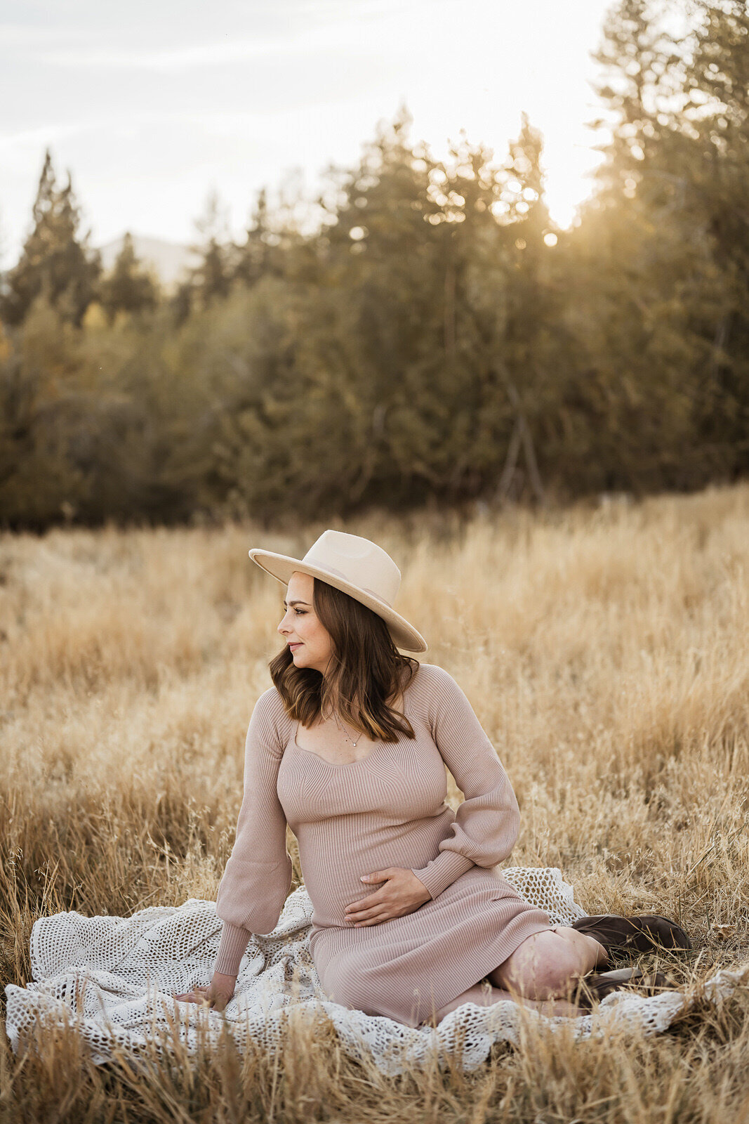 Woman cradling belly in nature's glow