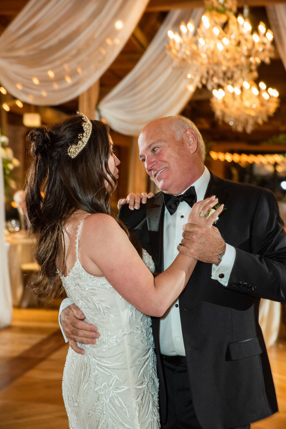 A man in a tuxedo is dancing with a woman in a wedding dress