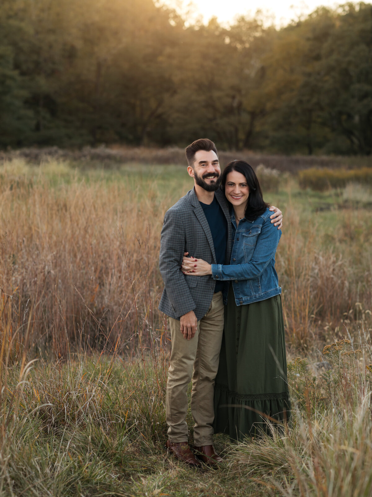 husband and wife hugging for family photos in field cleveland family photography