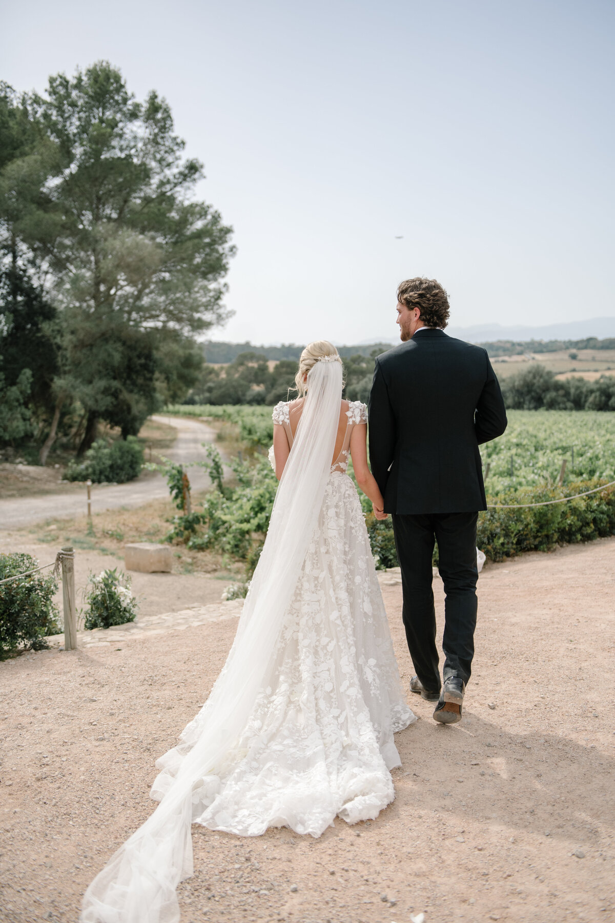 bride and groom walking through vineyards at finca serena wedding in mallorca