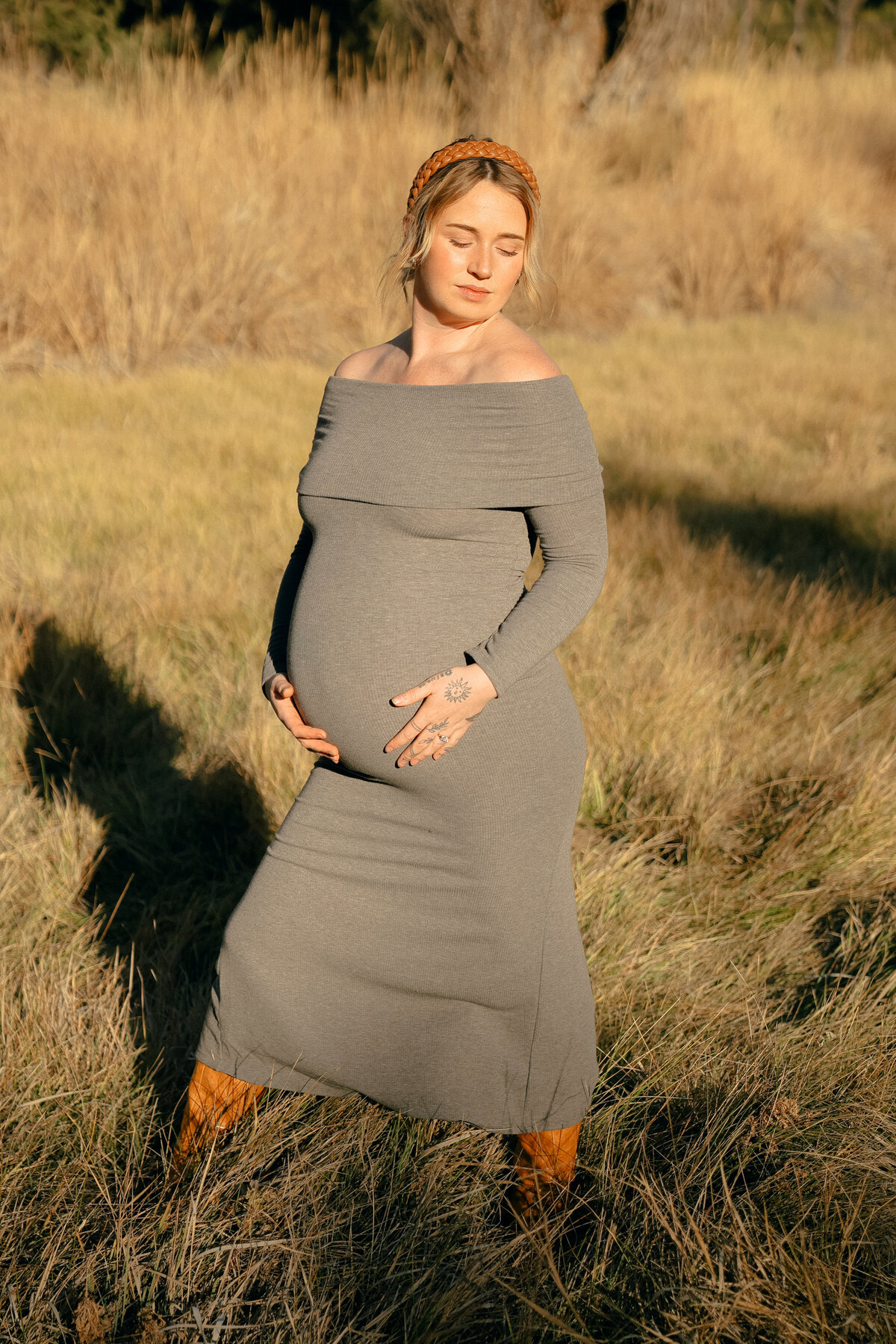 Golden Hour Maternity Portrait of Expecting Mother in Gray Dress Holding Baby Bump