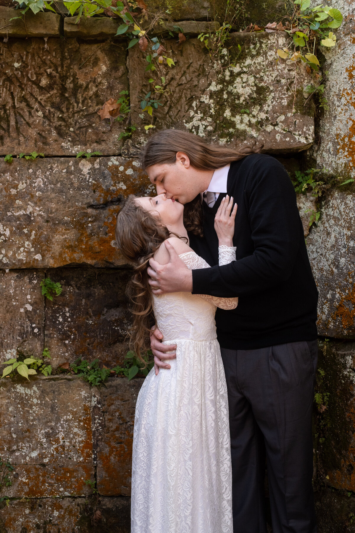 Couple kisses by stone wall at Lock 29 