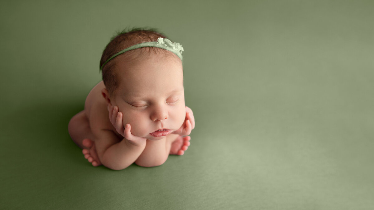 sleeping newborn on green background