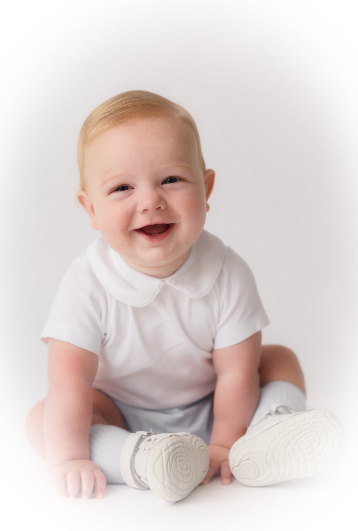 Baby grins into the camera during Heirloom Portrait session in Charleston, SC photo studio.