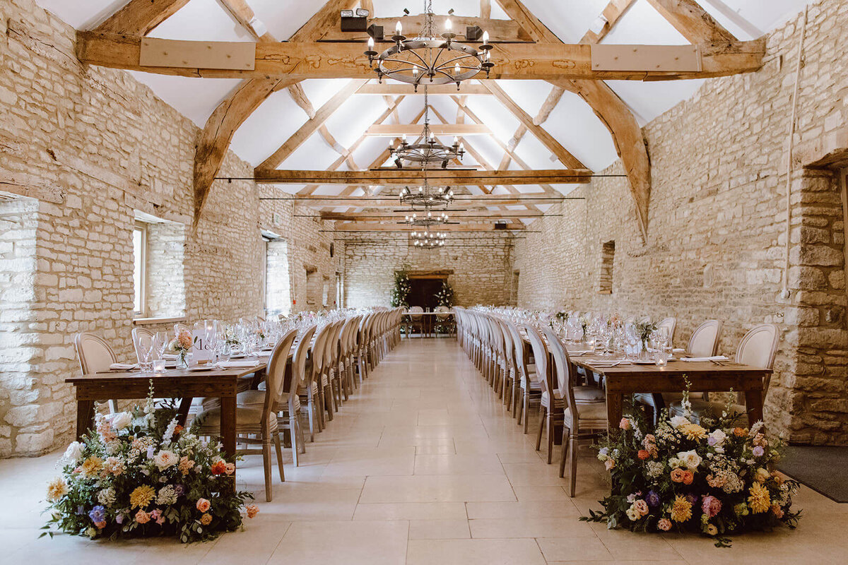 Light and airy wedding reception setup inside the luxury barn at Caswell House, Oxfordshire