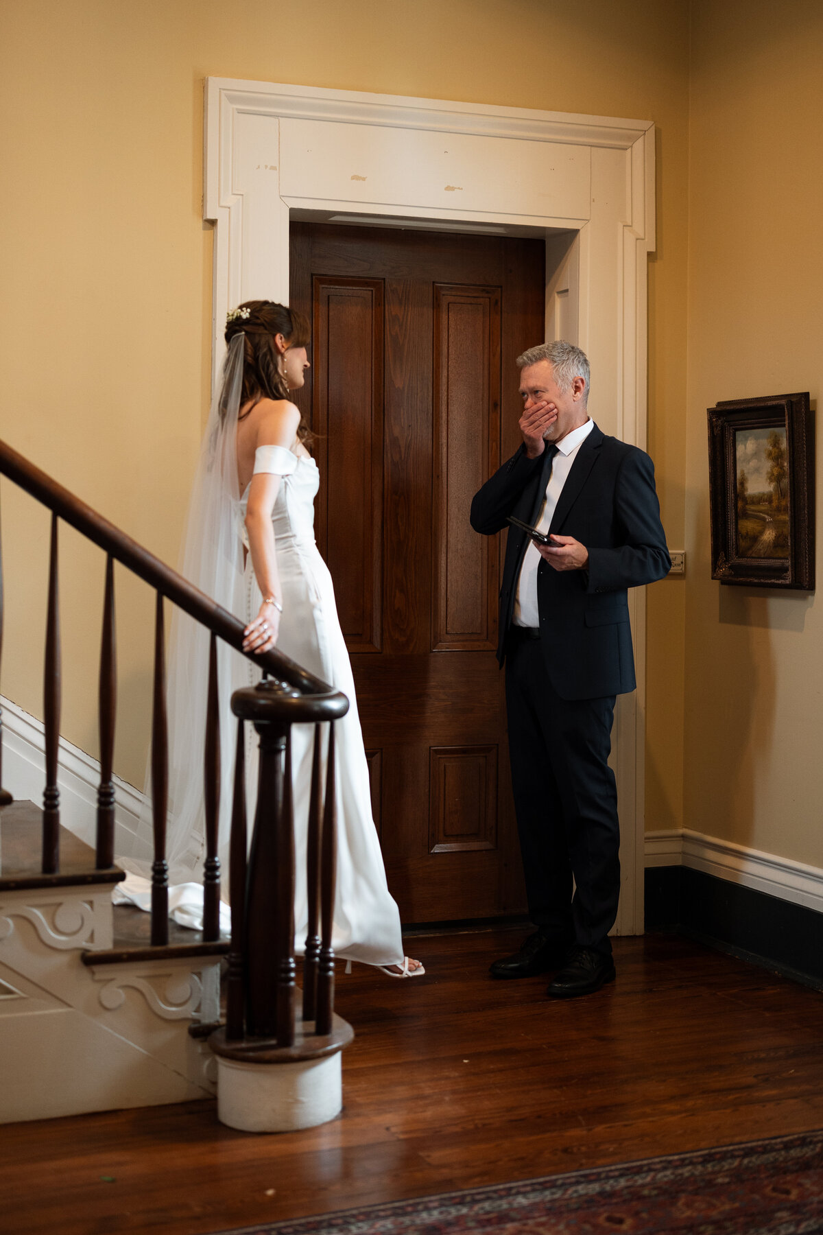 bride walks down stairs to surprise dad on wedding day
