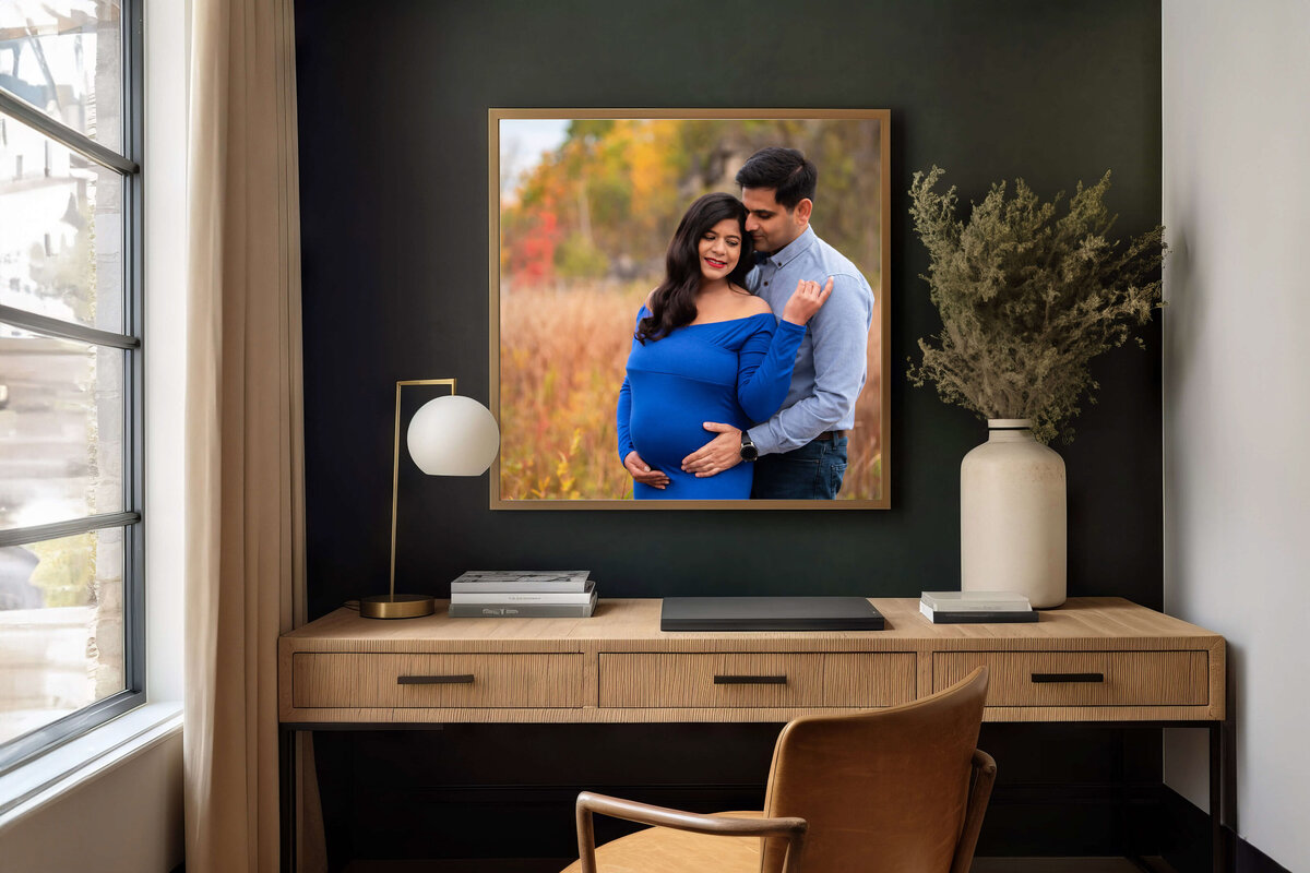 dark room with a framed photo of a couple at their fall outdoor maternity photography session in Burlington, On