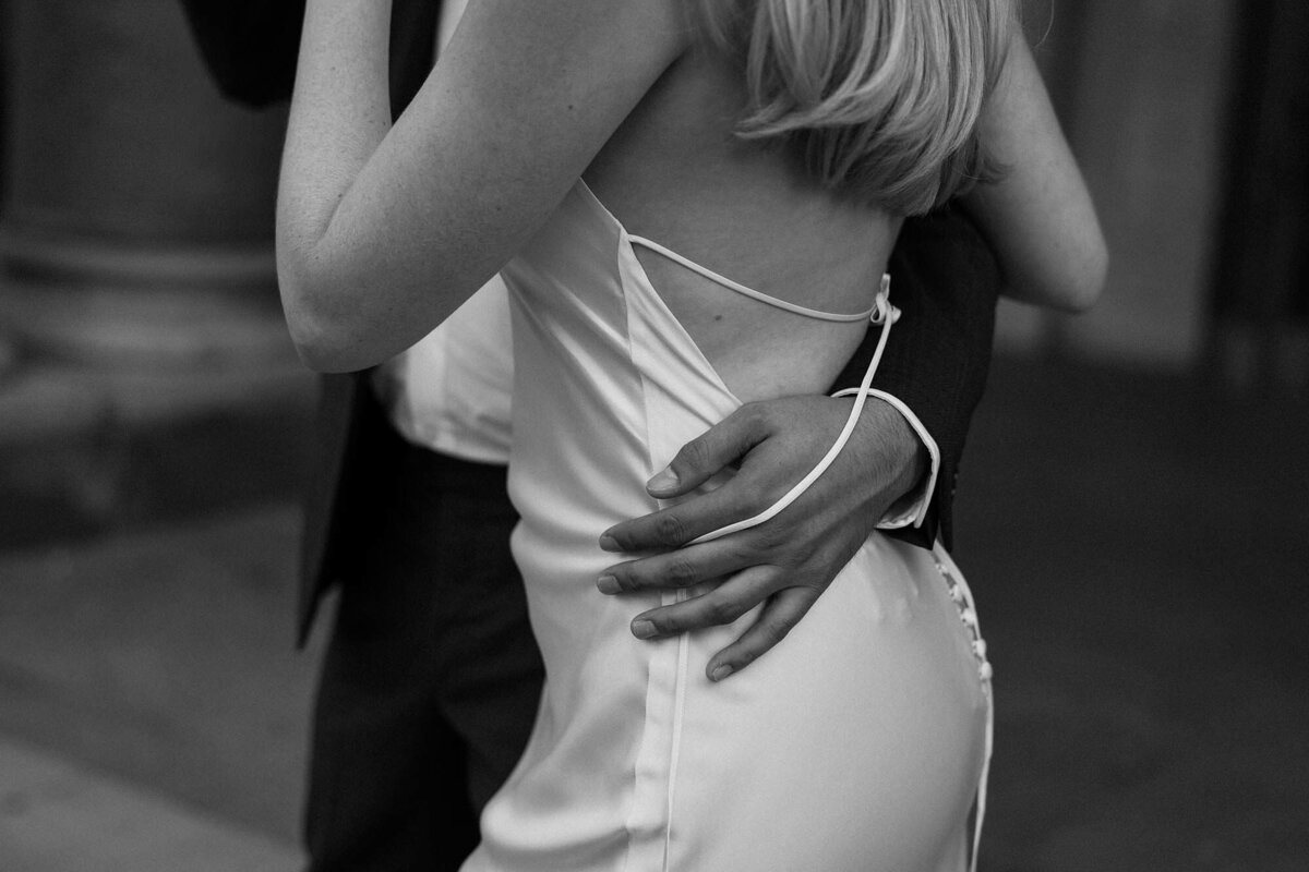 A close up of someone's hands around their partner's waist