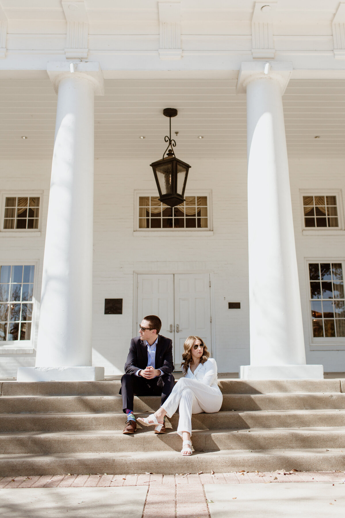 A couple casually sitting on steps after a Dallas elopement captured by Fort Worth wedding photographer, Megan Christine Studio